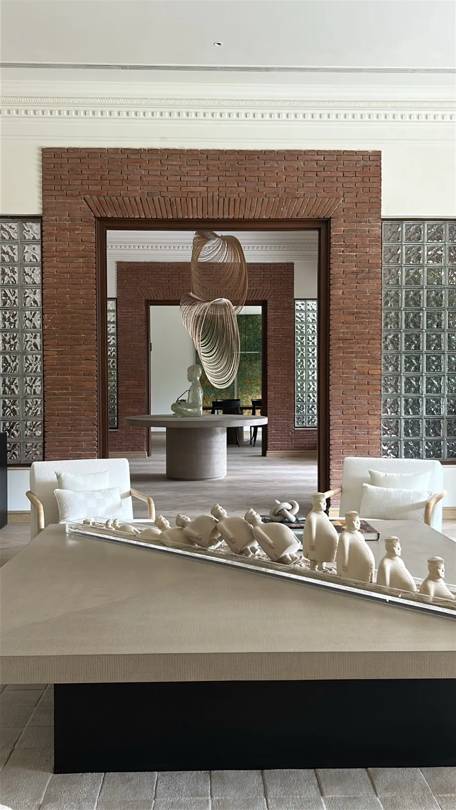 Brick portal with figurines and wire pendant at the Delhi farmhouse by Sonia Gehlot