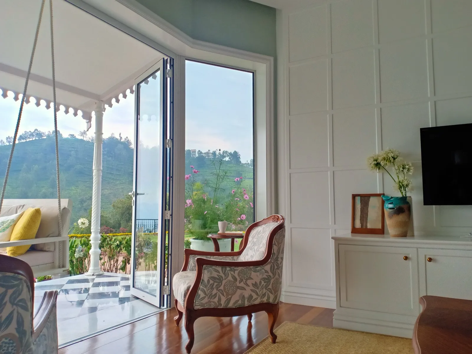 Living room opening to the verandah and tea gardens at Coonoor by Sonia Gehlot