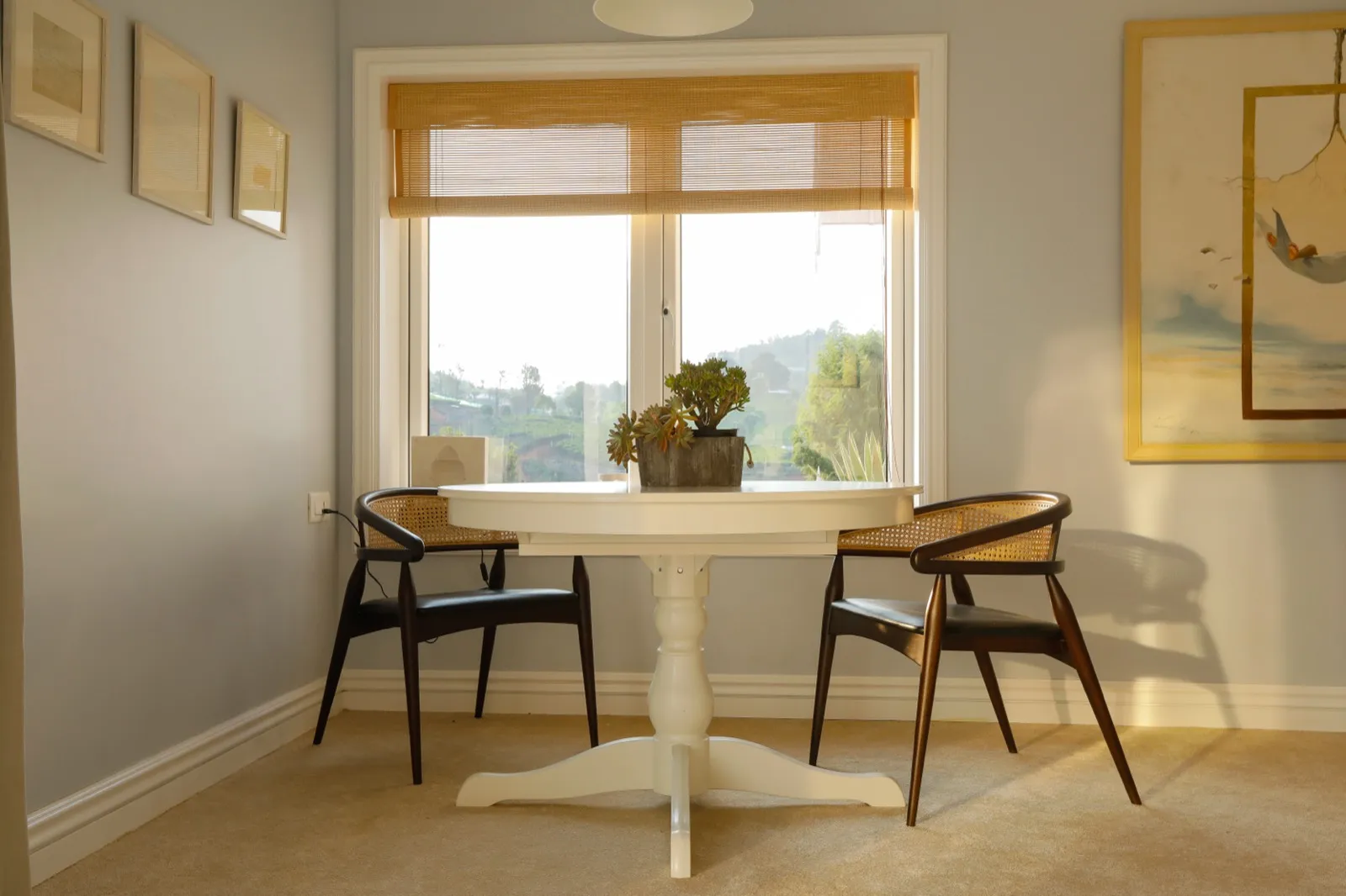 Breakfast table and cane chairs by the window at Coonoor by Sonia Gehlot