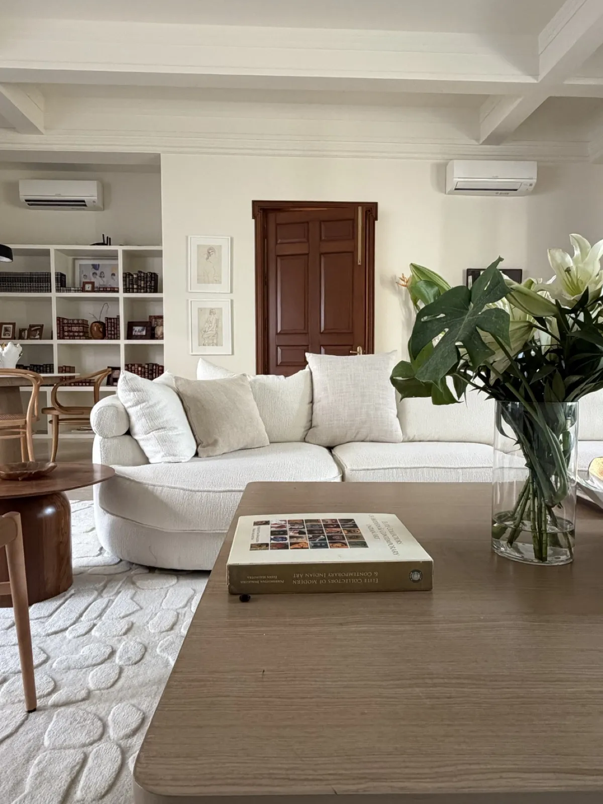 Cream living room with lilies and an art book by Sonia Gehlot
