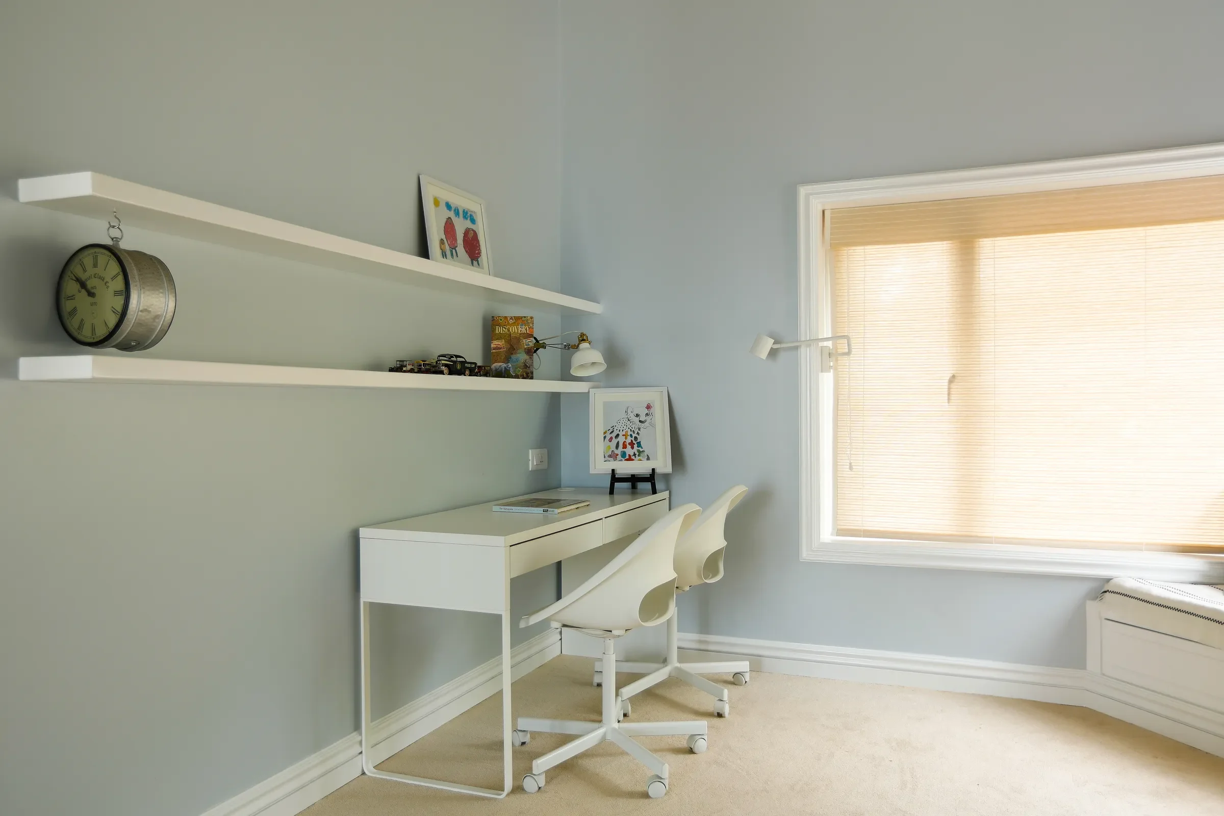 A desk and shelves in the pale blue room