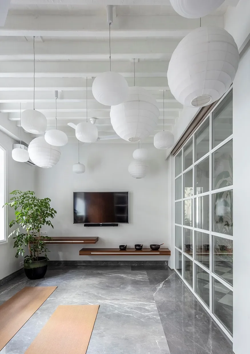 Paper lanterns under restored rafters in the meditation room