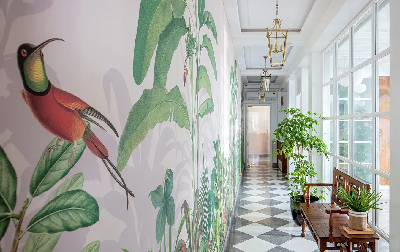 A corridor with a bird mural and checkerboard flooring