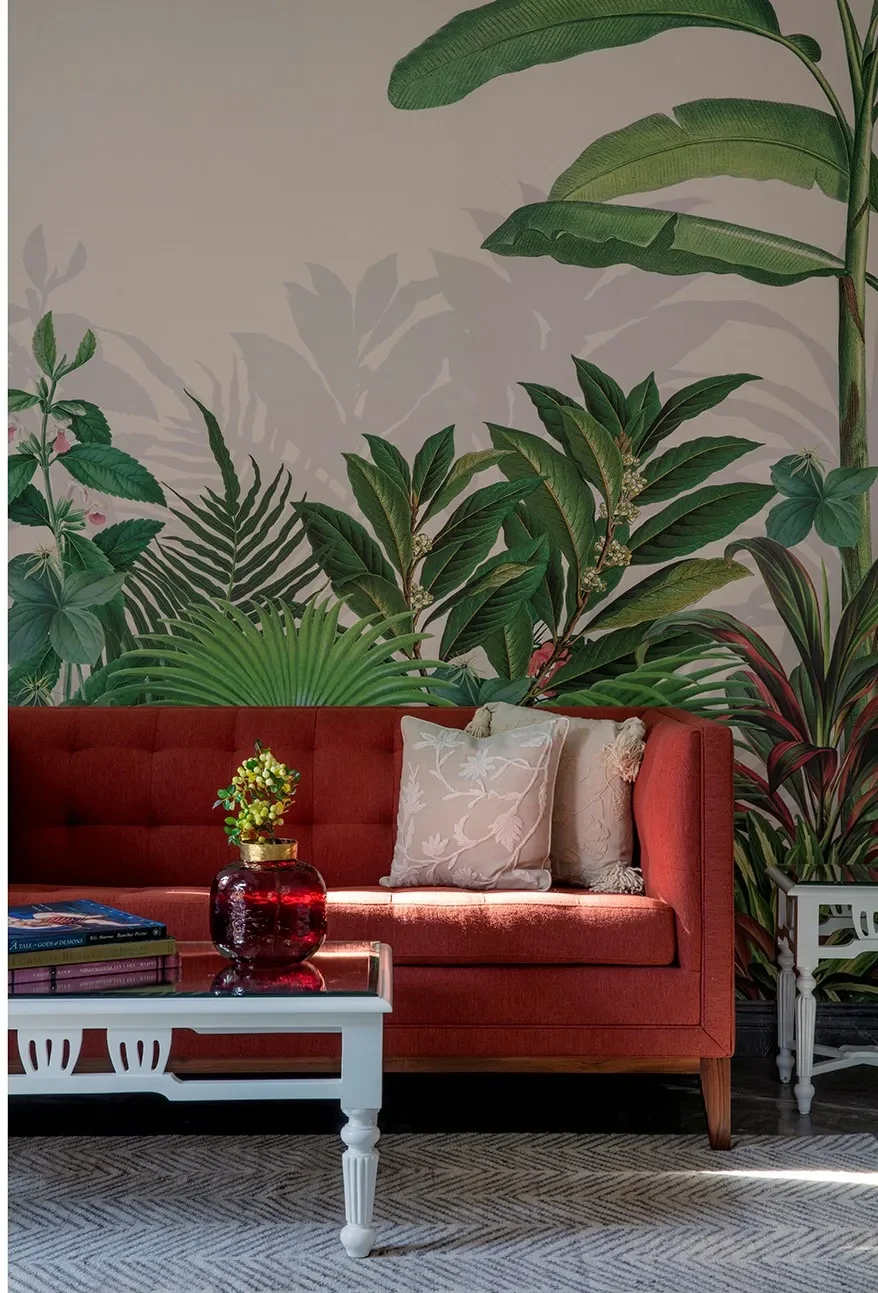 The painted garden mural behind the red sofa