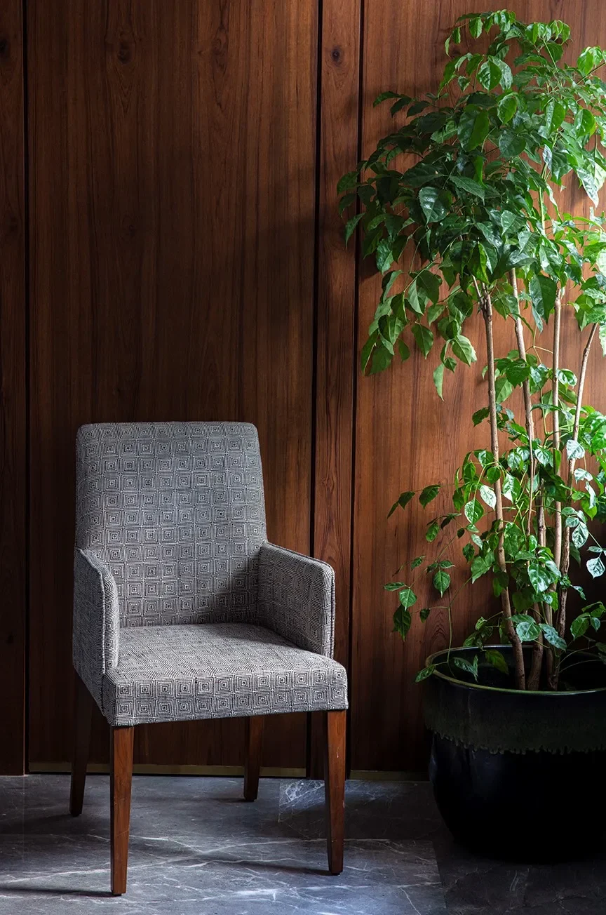 A grey armchair against fluted wood at The Healing Centre