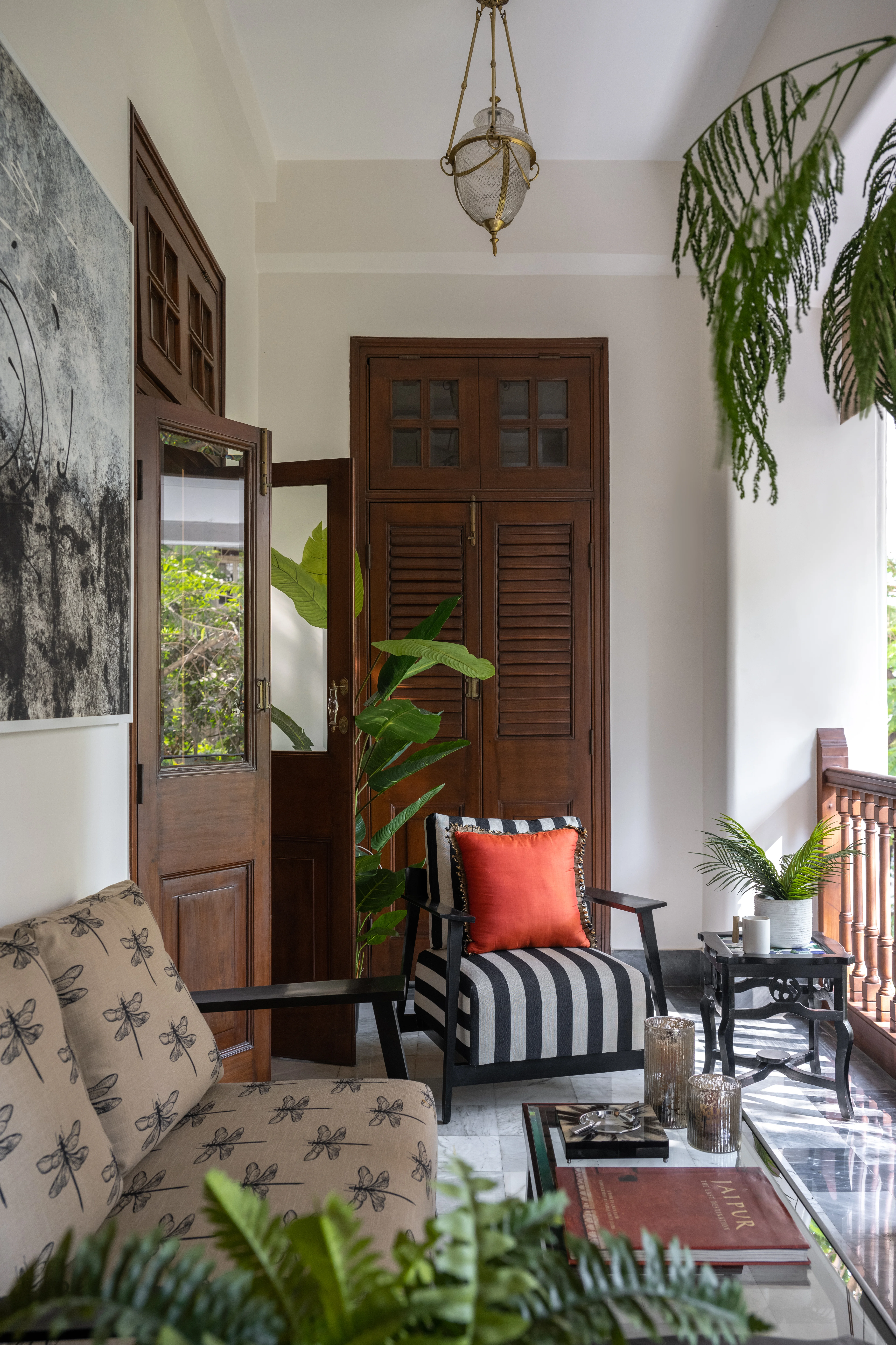 The balcony at Nook Home with heritage louvred doors and a striped armchair
