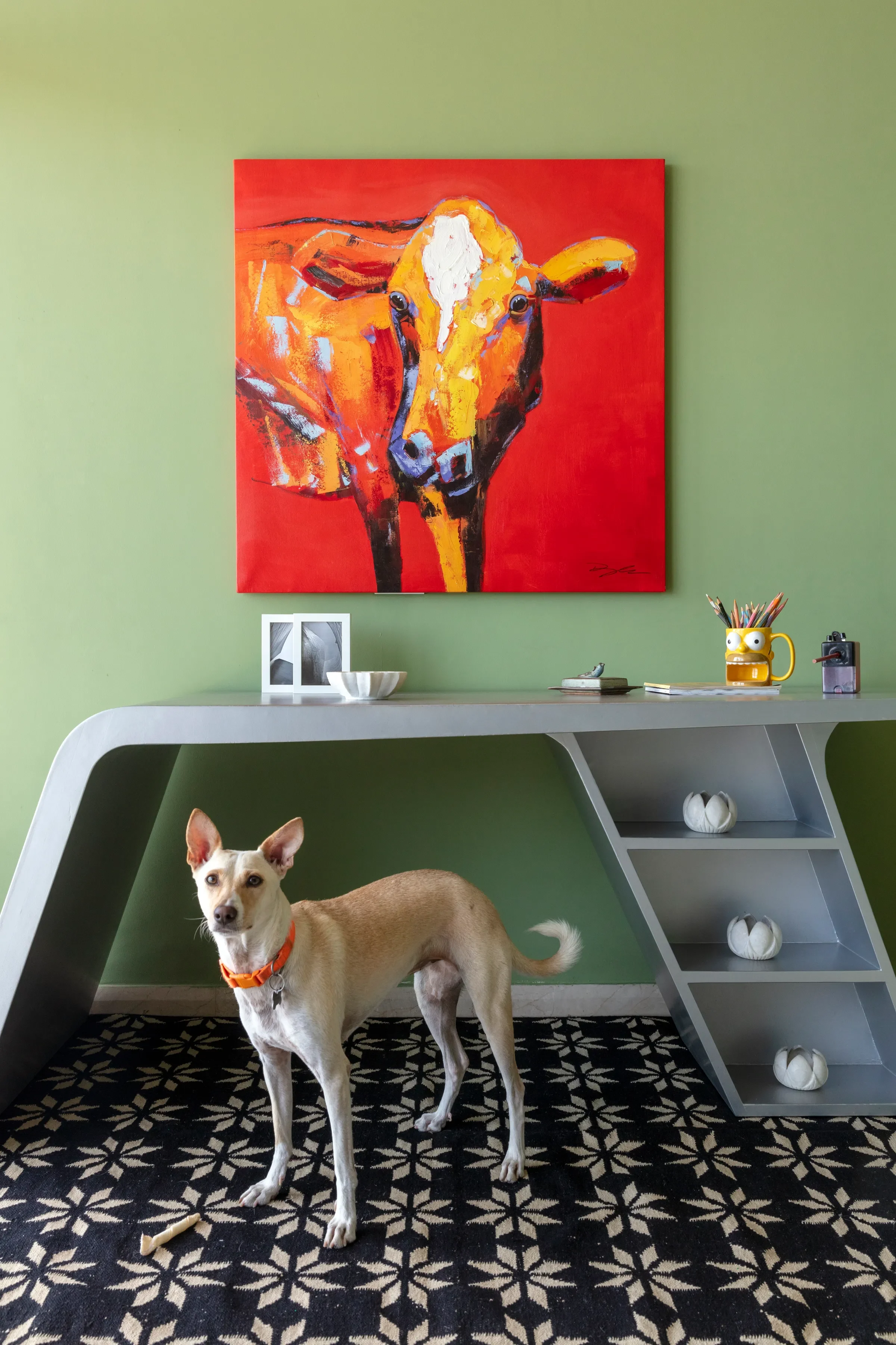 The green study at The Open Horizon, a painted cow above the desk