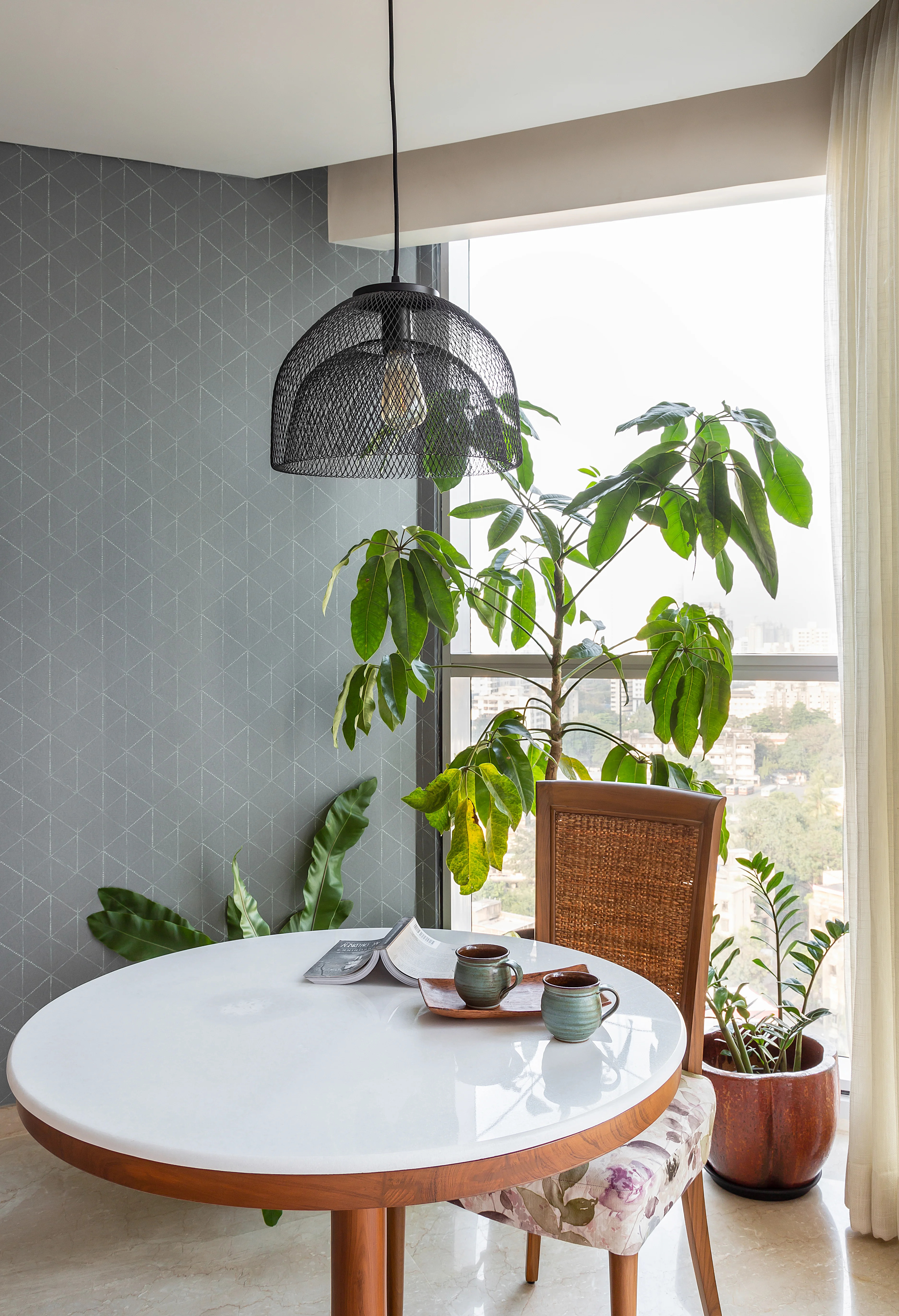 A cane chair and side table by the window at the mid-century apartment