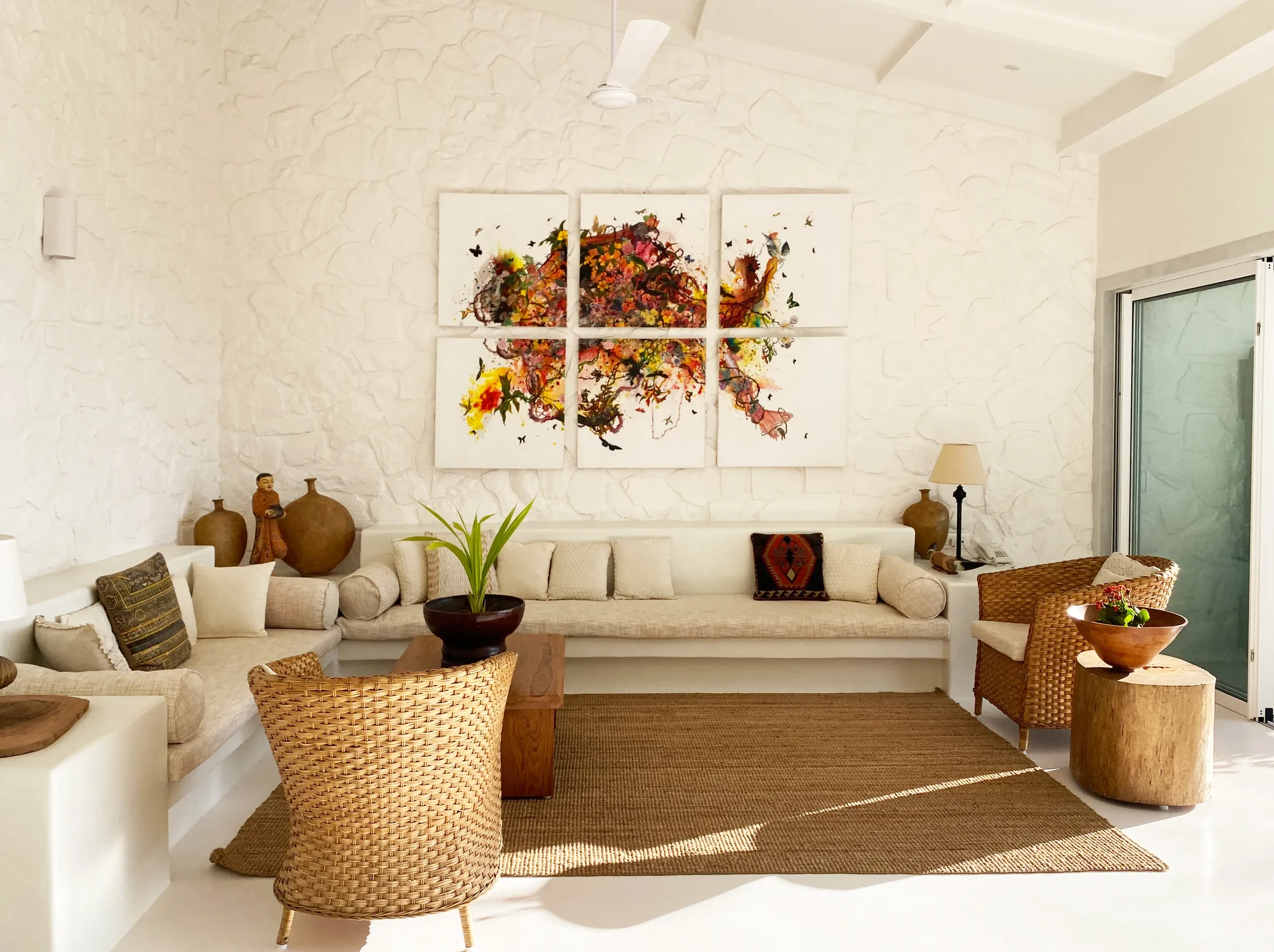 The long built-in sofa under a quartet of flower prints at the Marve beach house