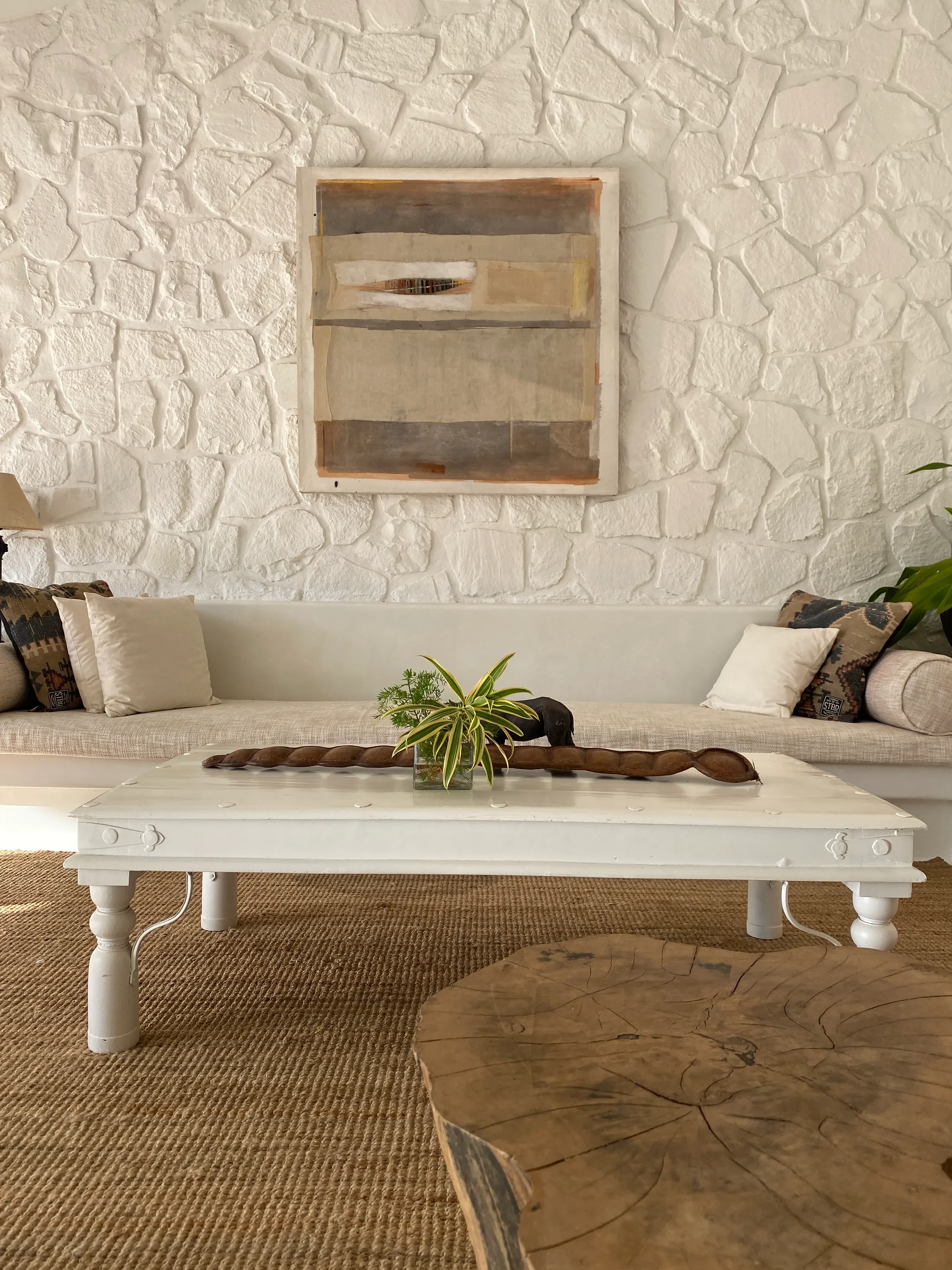 A framed work on the rough plastered wall at the Marve beach house