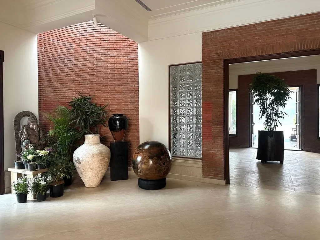 A brick arch and grouped pots in the hall at the Delhi farmhouse