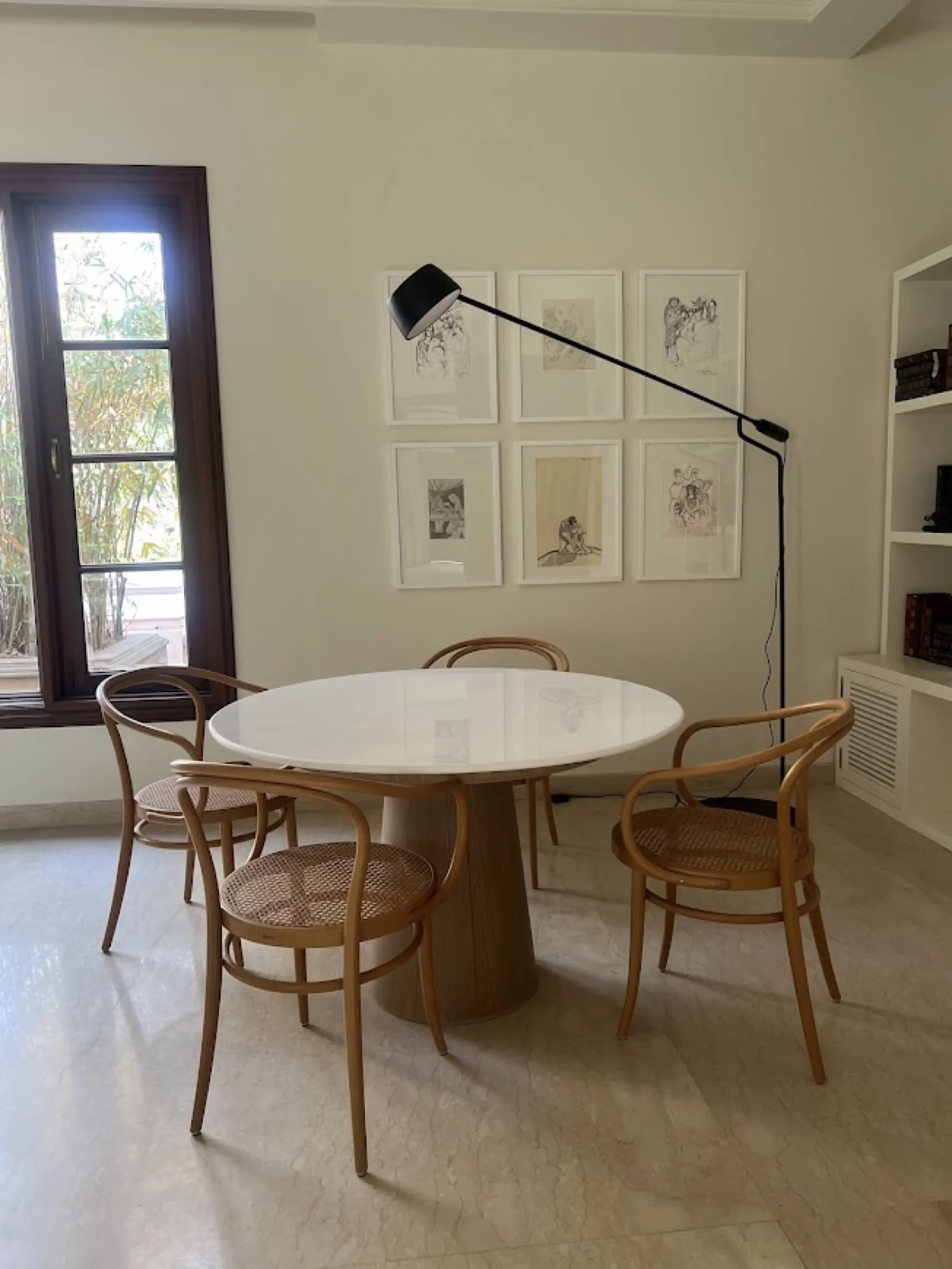 Reading nook with bentwood chairs and sketches at the Delhi farmhouse