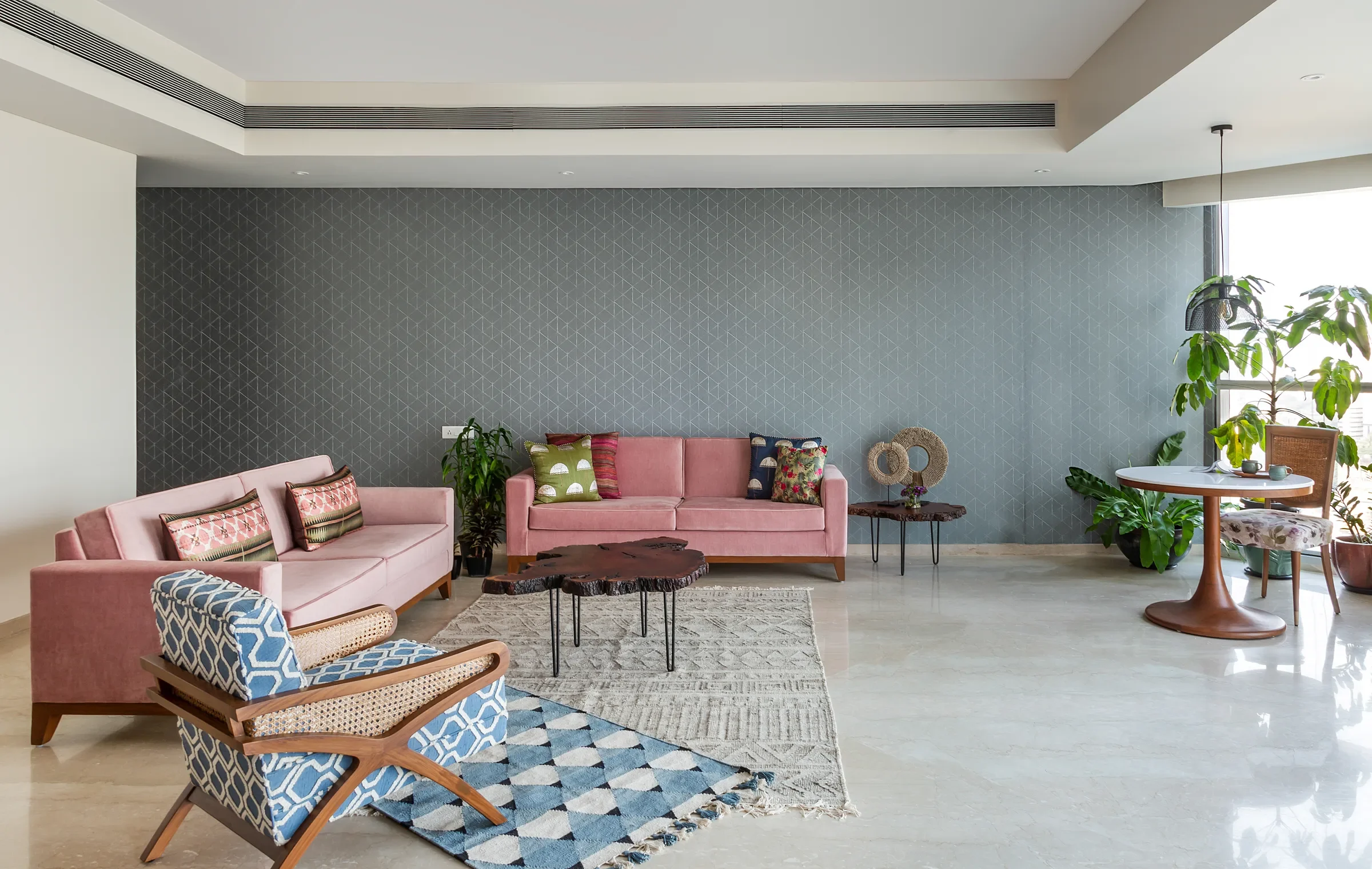Dusty-pink seating and a patterned rug in the mid-century apartment by Sonia Gehlot